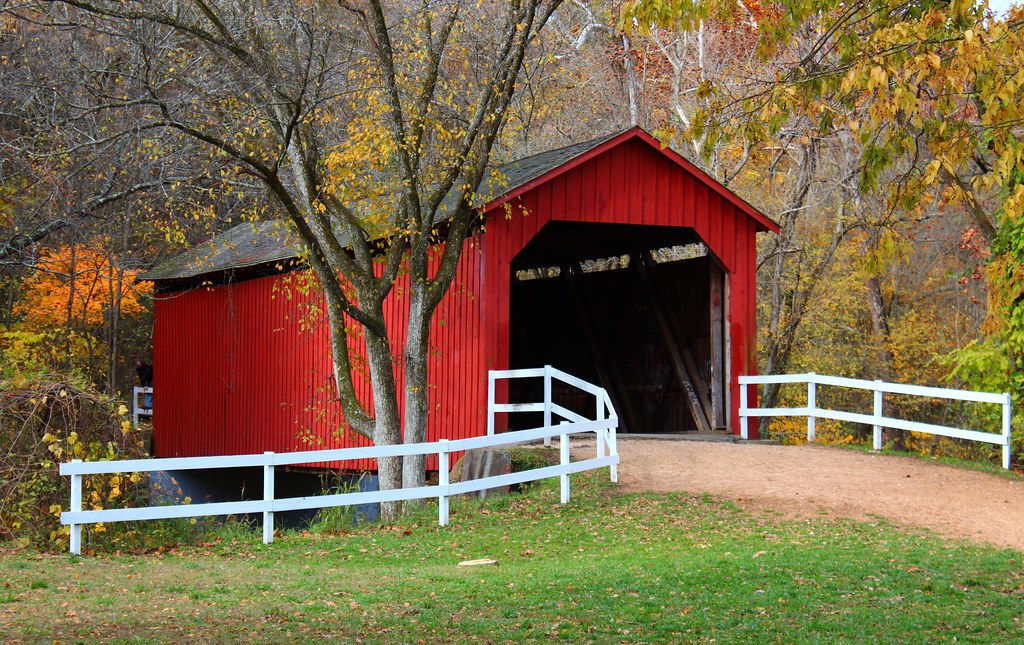 Red covered bridge surrounded by autumn trees in Jefferson County, Missouri